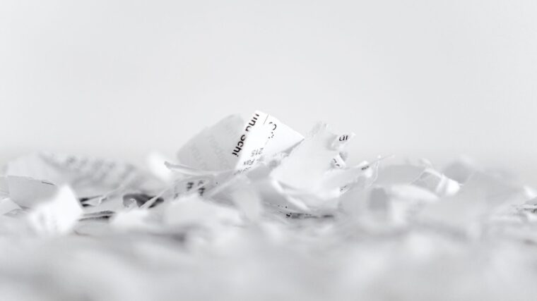 Papierzettel liegen zerknüllt auf dem Boden.